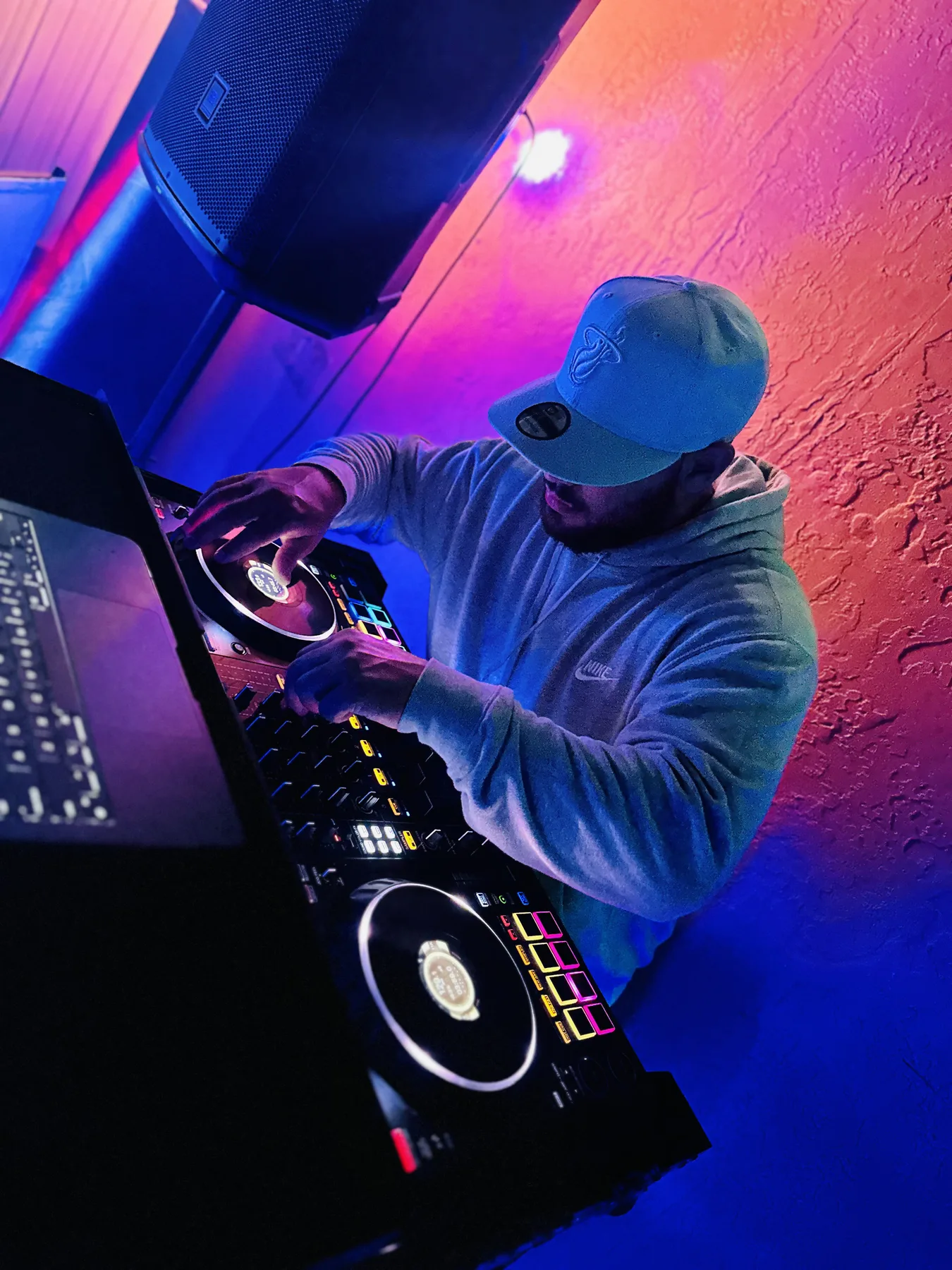 Booth Fairy Miami DJ controller and sound setup under pink and blue event lighting