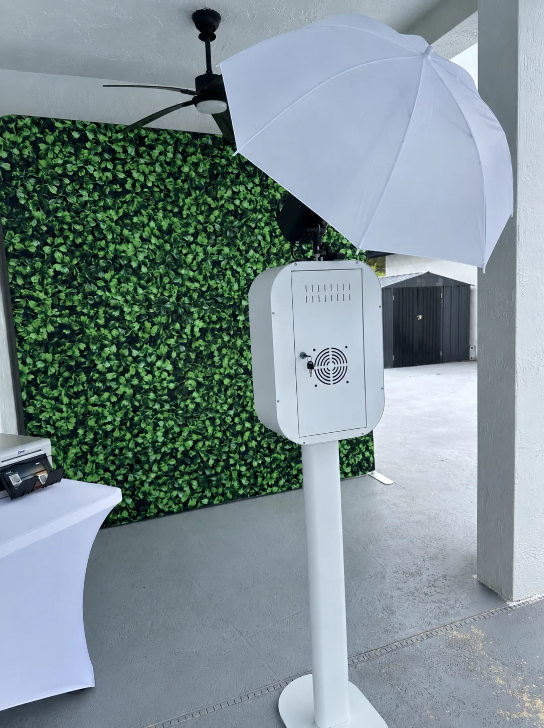 Booth Fairy Miami DSLR print photo booth with studio lighting, greenery backdrop, and printer station